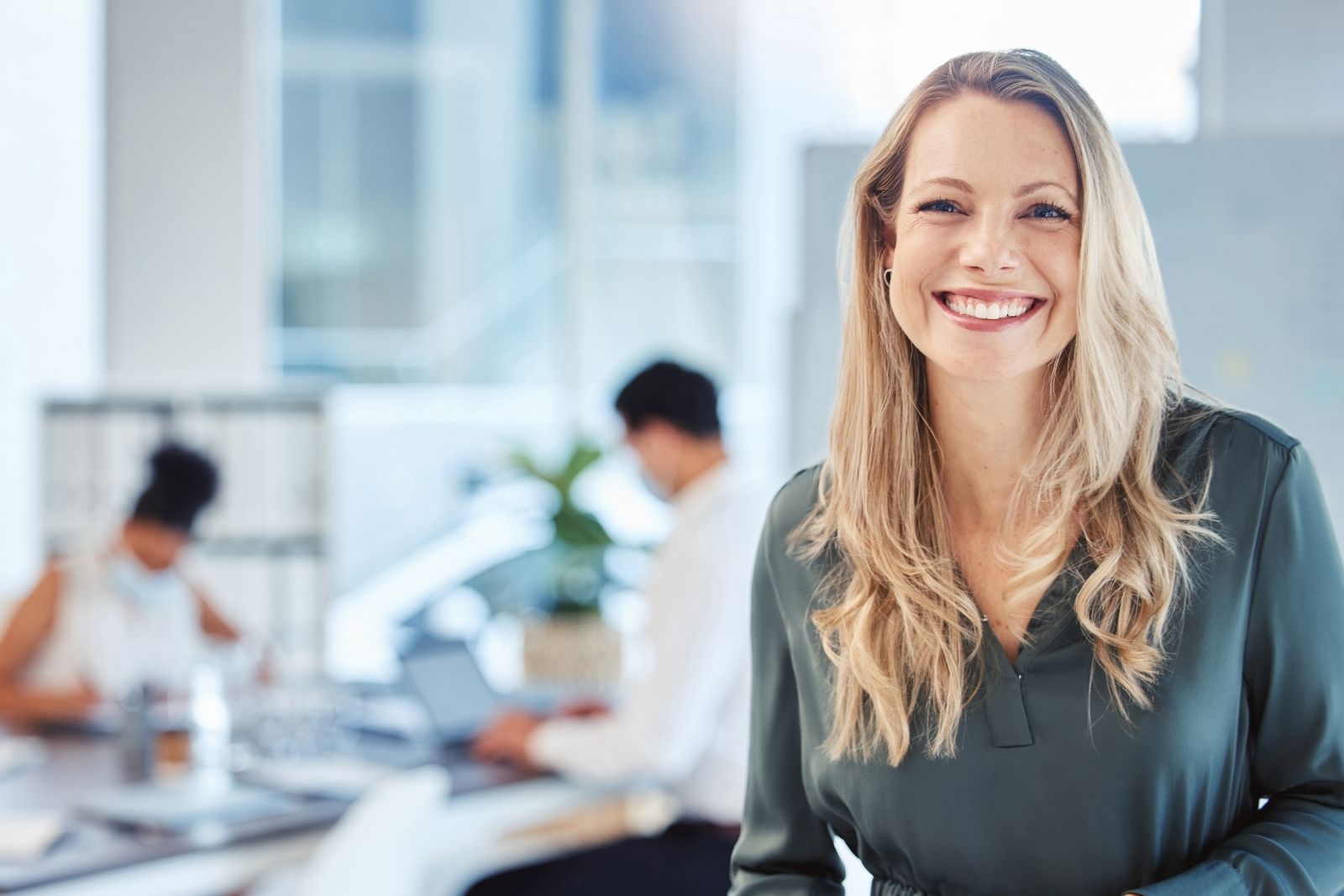 CX Skills trainer smiling with team working in a modern office