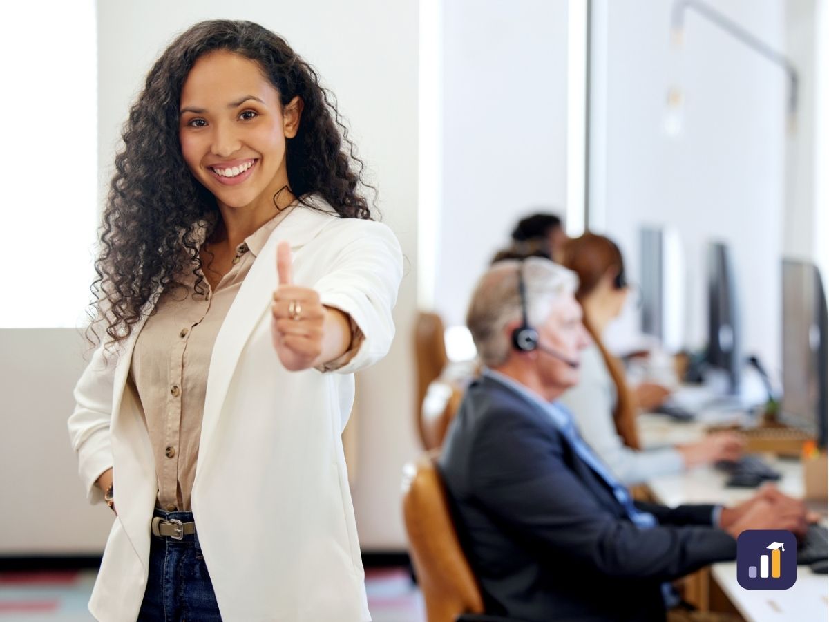 Smiling contact centre manager giving a thumbs up in front of her team