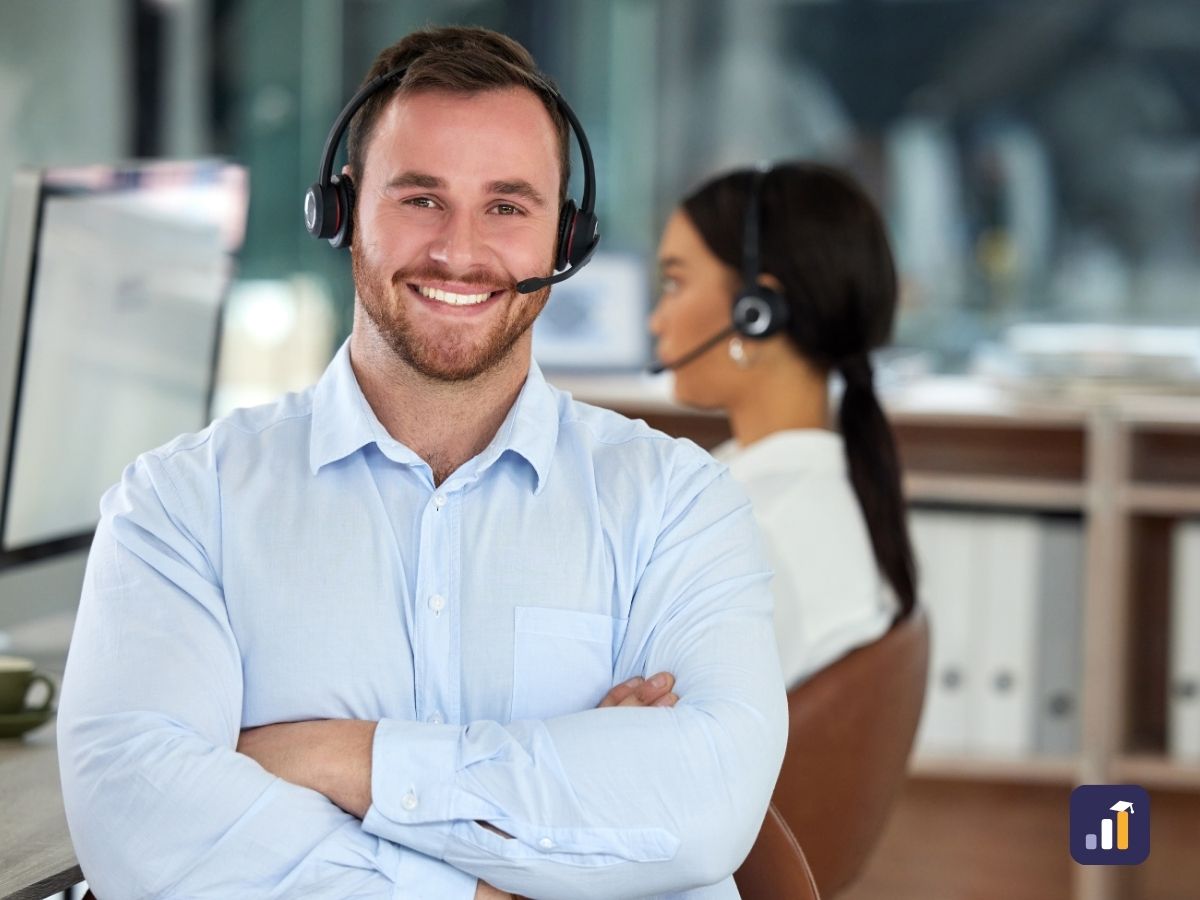 Smiling help desk team member with a headset, arms folded