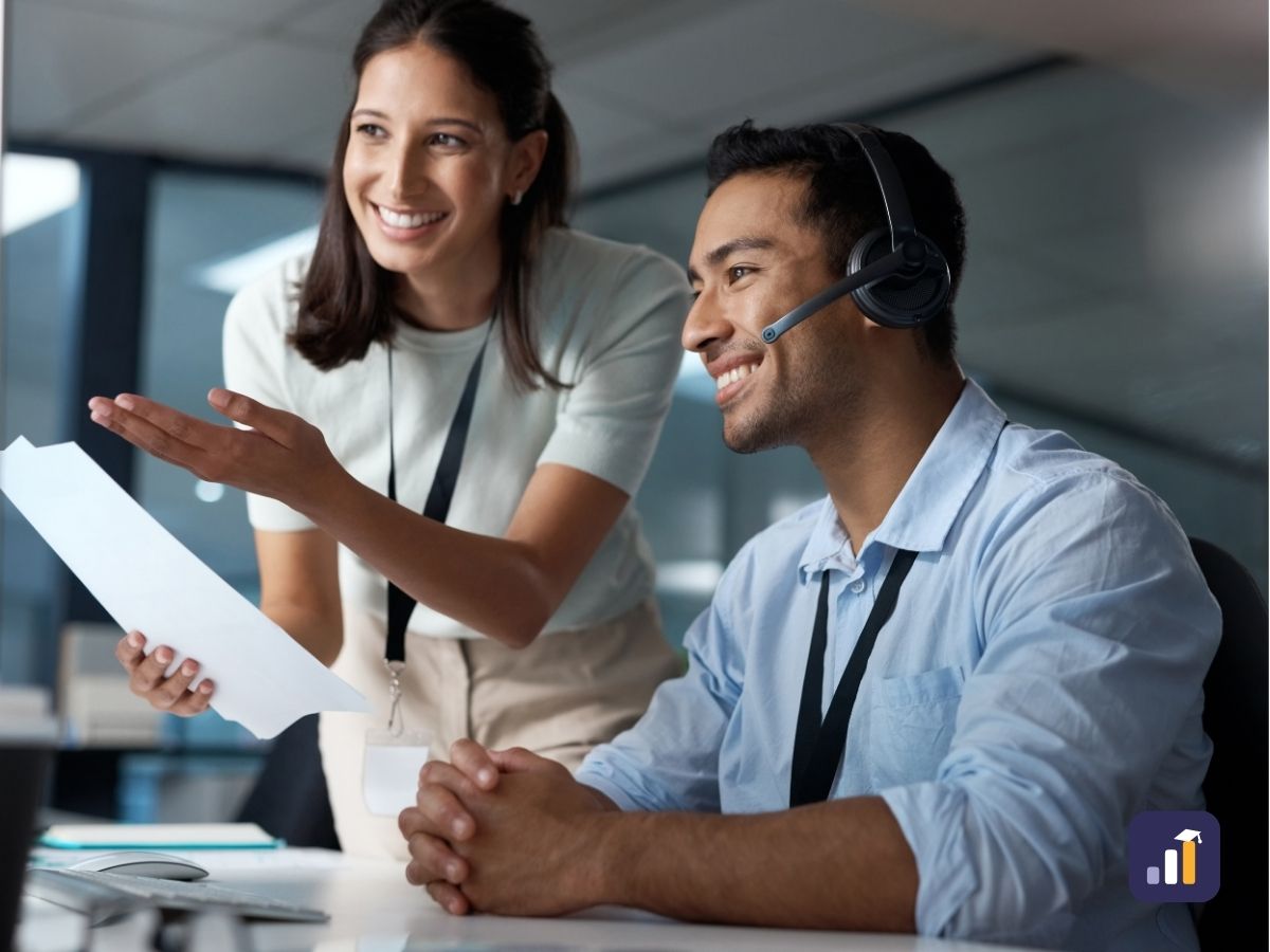 Contact centre manager guiding an agent at her desk