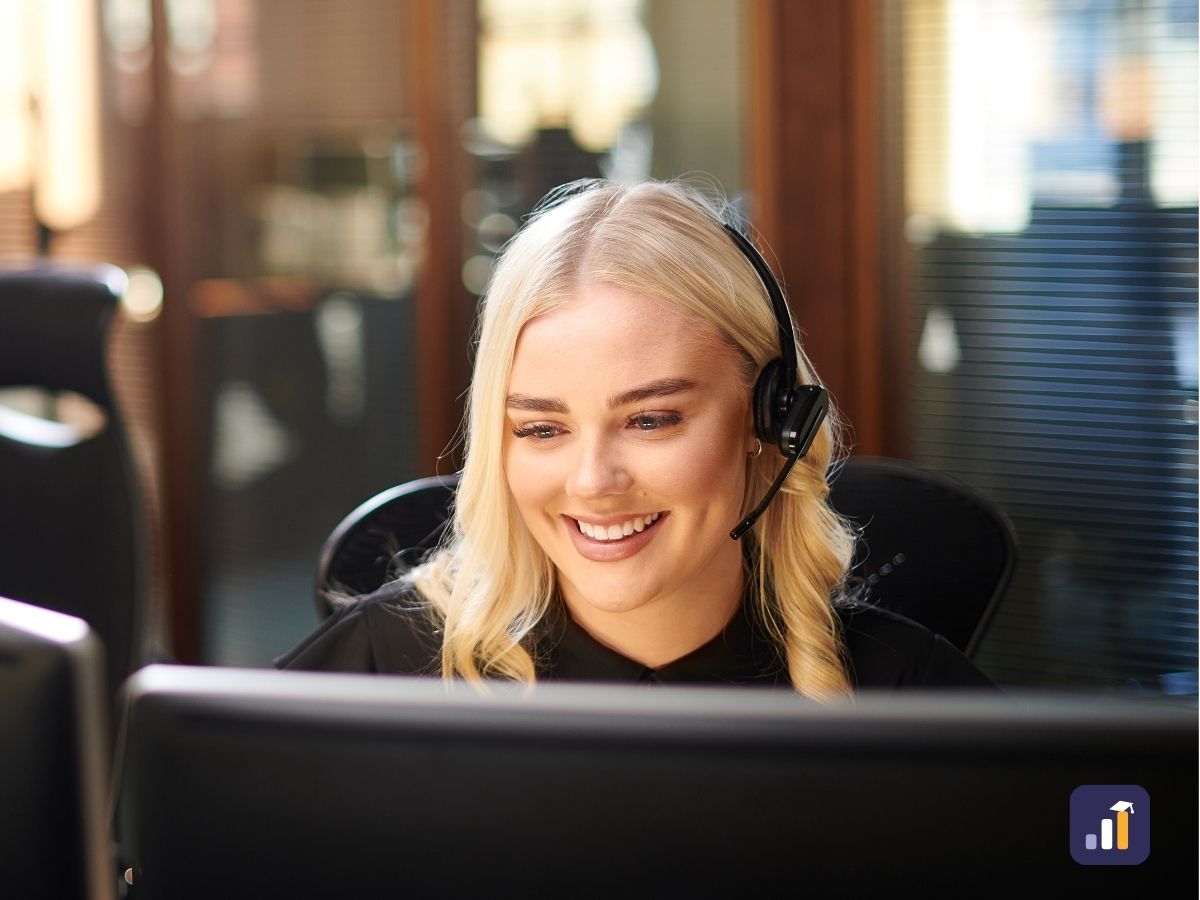 Smiling public sector officer with a headset at her computer