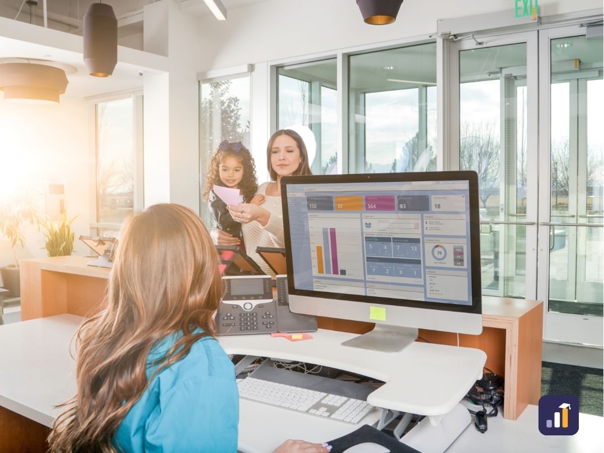 Receptionist at a front desk greeting a mother and daughter as they arrive